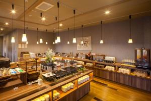 ein Restaurant mit einer Theke mit ausgestellten Speisen in der Unterkunft Hotel Route-Inn Tsuyama Ekimae in Tuyama