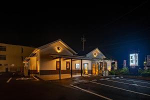 a church with a cross on the front of it at night at Hotel Route-Inn Tsuyama Ekimae in Tuyama