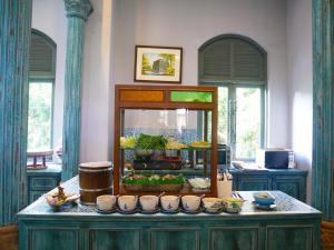 a counter with bowls and dishes on top of it at At Pingnakorn Huaykaew in Chiang Mai