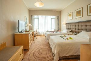 A bed or beds in a room at Shantou Junhua Haiyi Hotel