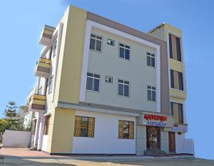 Krishna Kunj في أودايبور: مبنى اصفر وابيض عليه لافته
