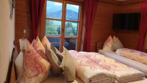 a room with two beds with pillows and a window at Landhaus Hoschek in Scheffau am Wilden Kaiser