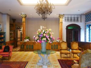 a lobby with a table with a vase of flowers at At Pingnakorn Huaykaew in Chiang Mai