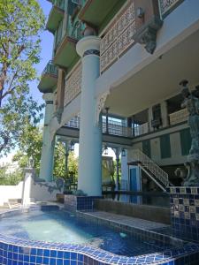 a building with a swimming pool in front of it at At Pingnakorn Huaykaew in Chiang Mai