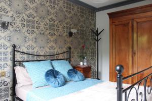 a bedroom with a bed with blue pillows on it at CHANTONNAY 2 chambres privées pour 4 personnes in Chantonnay