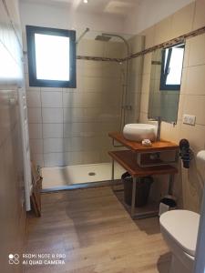 een badkamer met een douche, een wastafel en een toilet bij Sagone in Vico