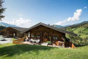 a log house with a porch and a patio at DAS "ZwisleggGut" in Wagrain