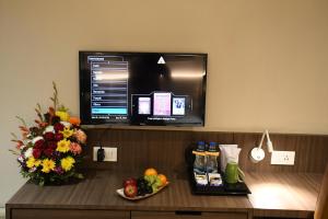 a desk in a hotel room with a bowl of fruit and a tv at LYNQ AERO in Kolkata