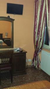 ローマにあるピタゴーラ B＆Bのベッドルーム(鏡、ドレッサー、カーテン付)