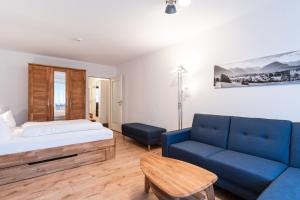 ein Schlafzimmer mit einem Bett und einem blauen Sofa in der Unterkunft Ferienwohnungen Sattler in Oberstdorf