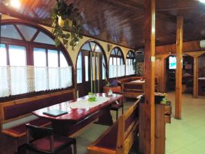 a dining room with a table and some windows at Bar & Guests room ELA in Dolen Bliznak