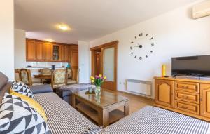 a living room with a couch and a clock on the wall at Apartman Mikulić Makarska in Makarska