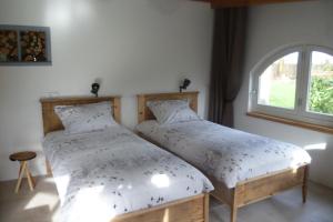 two beds in a room with a window at Beukenhof in Molenschot