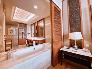 a bathroom with a large tub and a sink at The Danna Langkawi - A Member of Small Luxury Hotels of the World in Pantai Kok