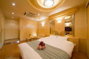 Un dormitorio con una cama grande con flores. en HOTEL THE i Adult only en Higashi-osaka