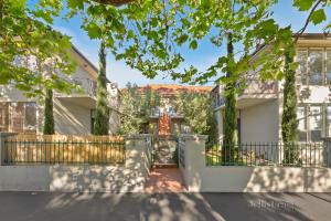 a house with a gate and trees at StayCentral - Brunswick Vibe Parkville in Melbourne