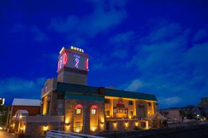 a building with a clock tower at night at HOTEL THE i Adult only in Higashi-osaka