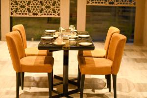 a dining room table with chairs and a table set with dishes at LYNQ AERO in Kolkata