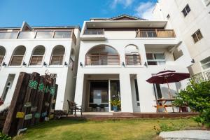 un grande edificio bianco con un prato davanti di Banff-Penghu B&B a Magong