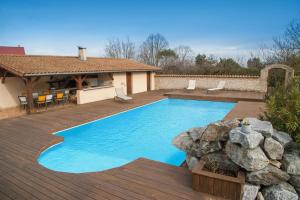 a swimming pool with a deck and a house at LA MADELEINE DE JAILLANS in Jaillans