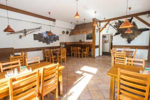 a restaurant with wooden tables and wooden chairs at Hotel Seifert in Nové Hamry