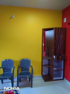 une salle d'attente avec deux chaises bleues et un mur jaune dans l'établissement Shiva Shanti Guest House, à Arambol