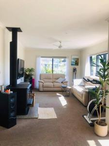 a living room with a couch and a fireplace at Mangawhai Room in Mangawhai