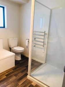 芒格菲的住宿－Mangawhai Room，一间带卫生间和玻璃淋浴间的浴室
