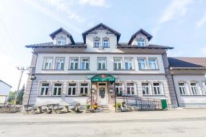 a large white building with a gambrel roof at Hotel Seifert in Nové Hamry