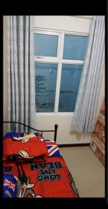 a bedroom with a bed with a large window at 2 BR Jungle Decor Beautiful Sea View Fast Internet Top Of The Mall in Jakarta