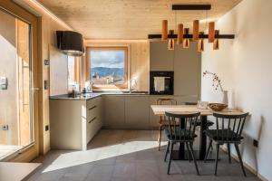 cocina con mesa, sillas y ventana en Landhaus Silene, en Sarnonico