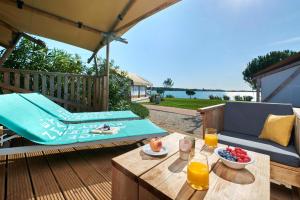 a patio with a table and a couch and an umbrella at Camping Park Umag Glamping in Umag