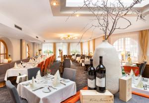 a restaurant with white tables and bottles of wine at Seiblishof Superior Hotel Ischgl in Ischgl