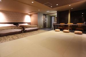 a bedroom with two beds and a table and chairs at Chiba sta 1min J hotel 2020 Open in Chiba