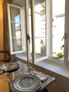 a table with two plates and two windows at Old Town Charm & Central Location in Rapperswil in Rapperswil-Jona