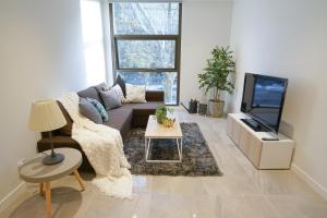 a living room with a couch and a tv at SYDNEY CBD WALK TO DARLING HARBOUR MODERN 1 BED APT NSY188 in Sydney