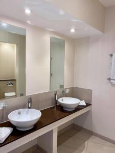 a bathroom with two sinks and a large mirror at Roman Way Hotel in Cannock