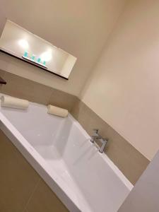 La salle de bains est pourvue d'une grande baignoire et d'un lavabo. dans l'établissement Roman Way Hotel, à Cannock