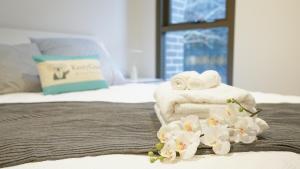 a bedroom with towels and flowers on a bed at SYDNEY CBD WALK TO DARLING HARBOUR MODERN 1 BED APT NSY188 in Sydney