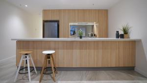 a kitchen with a counter and two stools at SYDNEY CBD WALK TO DARLING HARBOUR MODERN 1 BED APT NSY188 in Sydney