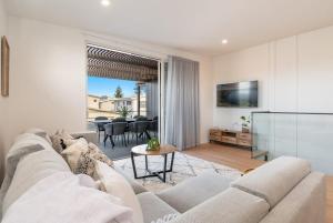 a living room with a couch and a table at 22 North - Lennox Head in Lennox Head