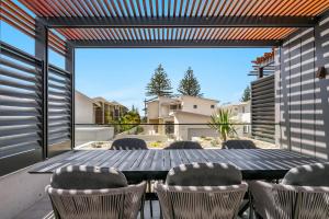 an outdoor patio with a table and chairs at 22 North - Lennox Head in Lennox Head