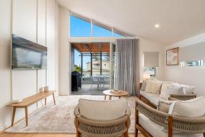 a living room with a couch and chairs at 22 South - Lennox Head in Lennox Head