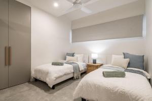 two beds in a room with white walls at 22 South - Lennox Head in Lennox Head
