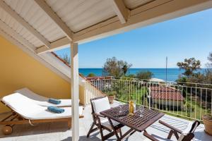 une terrasse avec une table et des chaises et l'océan dans l'établissement Albouro Seafront Apartments, à Kateliós