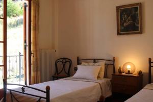 1 dormitorio con 2 camas y ventana en Velia Guesthouse, en Kalavrita