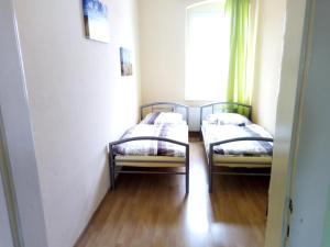 two beds in a room with a window at Ferienwohnung Erzgebirge in Geyer