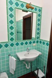 a bathroom with a sink and a mirror at Appartamento signorile con vista Caprera in La Maddalena