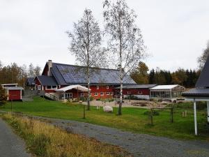 un granero rojo grande con un edificio en el fondo en Topperyd Bed & Breakfast, en Nässjö