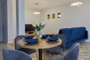 uma sala de jantar com uma mesa e cadeiras azuis em Luksusowy Apartament em Ostrów Wielkopolski